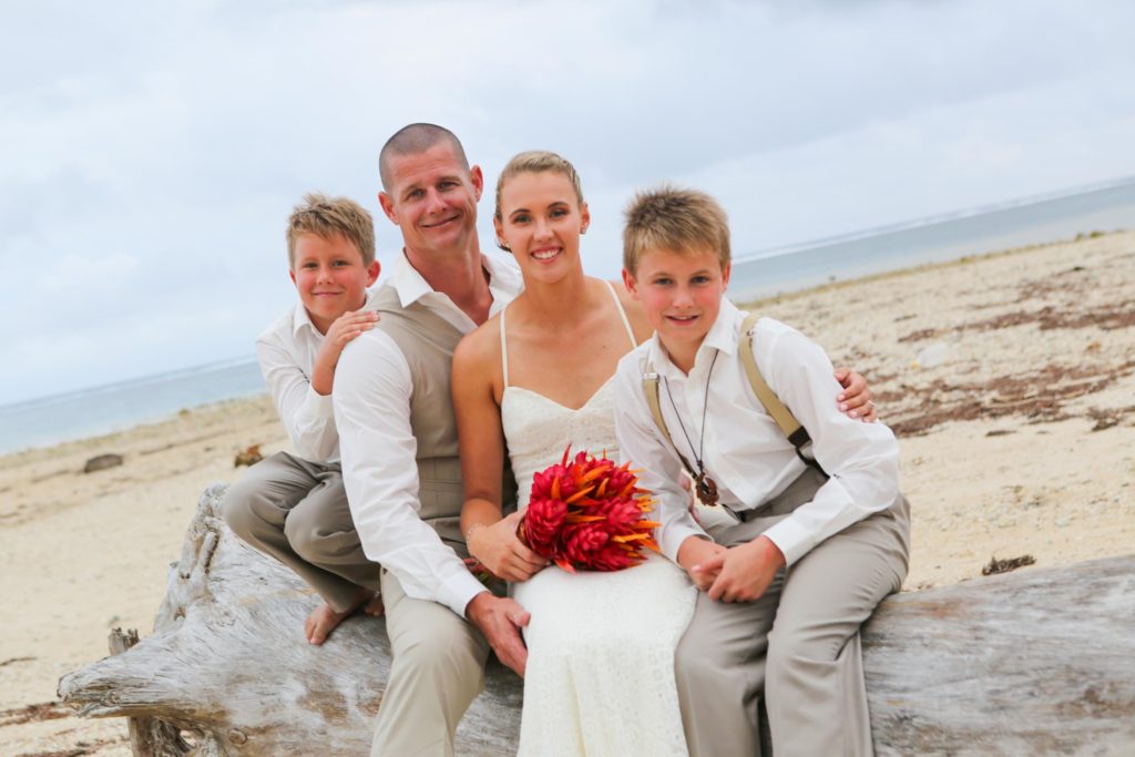 Wedding couple with two kids on the beach
