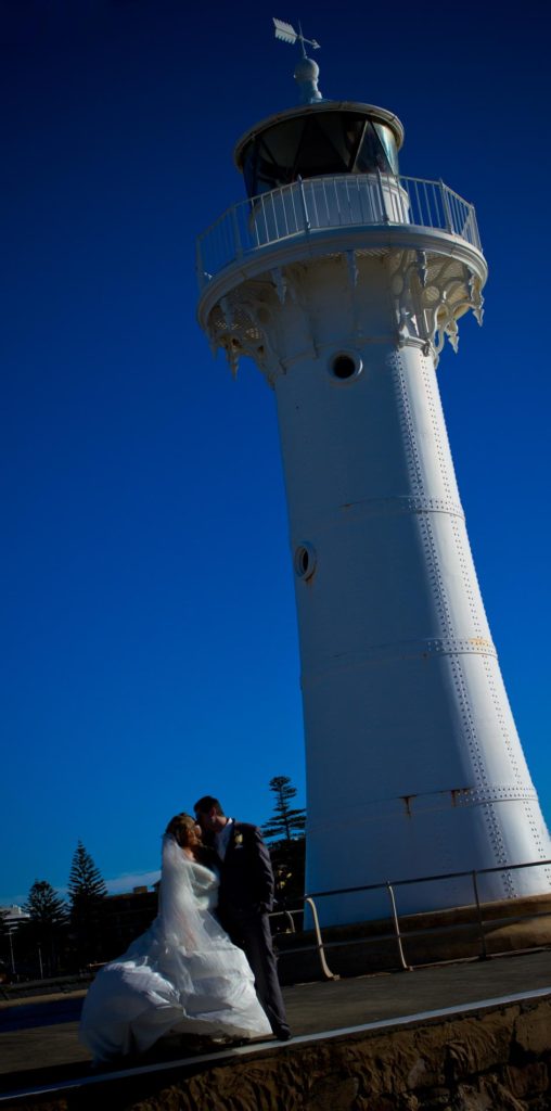 wedding couple shot in front of a lighthouse